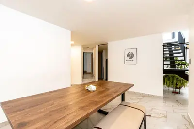 a dining room with a wooden table and chairs at L1 7BR Laureles House rooftop jacuzzi AC in Medellín