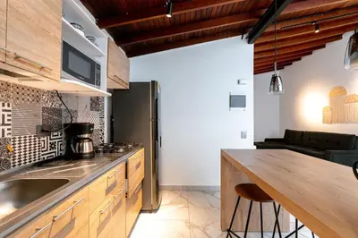 a kitchen with a wooden counter top and a kitchen with a table at L3 9BR Laureles House Rooftop 2 Jacuzzis AC in Medellín