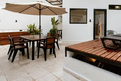 a dining room with a table and an umbrella at L3 9BR Laureles House Rooftop 2 Jacuzzis AC in Medellín