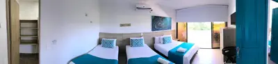 a bedroom with two beds with blue pillows at Hotel Aldea Plaza in Doradal