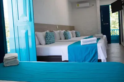 two beds in a room with blue and white at Hotel Aldea Plaza in Doradal