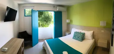 a bedroom with a bed and a sliding glass door at Hotel Aldea Plaza in Doradal