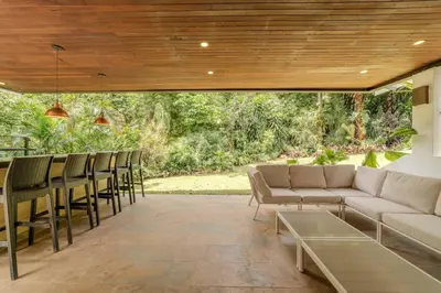 a patio with a couch and chairs and a table at CH65 Luxury 5BR Villa Jacuzzi Garden de Oro in Medellín