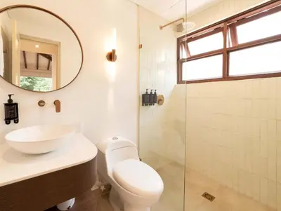 a bathroom with a toilet and a sink and a mirror at CH65 Luxury 5BR Villa Jacuzzi Garden de Oro in Medellín