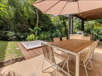 a table and chairs with an umbrella on a patio at CH65 Luxury 5BR Villa Jacuzzi Garden de Oro in Medellín