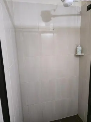 a bathroom with a shower with a white tiled wall at Casa completa Comodidad-Ubicación Perfecta-CarmenV in Carmen de Viboral
