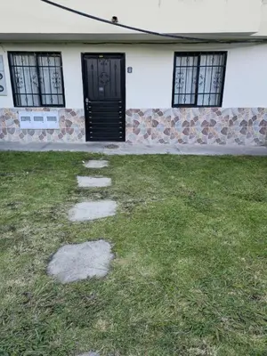 a building with a black door and a grass yard at Casa completa Comodidad-Ubicación Perfecta-CarmenV in Carmen de Viboral