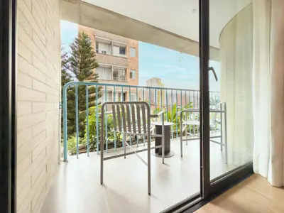 a room with a balcony with a chair on it at Hotel Once22 in Sabaneta