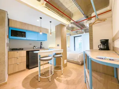 a kitchen with a counter and two stools in a room at Hotel Once22 in Sabaneta