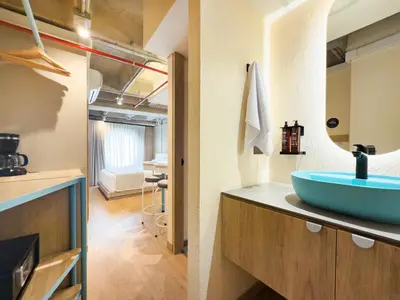 a bathroom with a blue sink on a counter at Hotel Once22 in Sabaneta