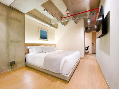 a bedroom with a white bed and a tv at Hotel Once22 in Sabaneta