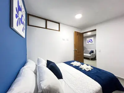 a bedroom with a blue and white bed with pillows at Apartamento Florelba-a solo dos cuadras del parque in Carmen de Viboral