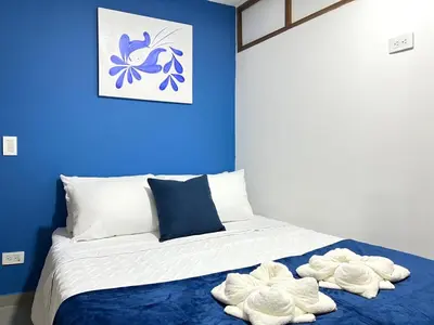 a blue bedroom with a bed with towels on it at Apartamento Florelba-a solo dos cuadras del parque in Carmen de Viboral