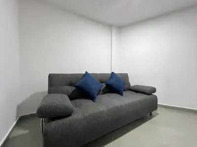 a couch with two blue pillows in a room at Apartamento Florelba-a solo dos cuadras del parque in Carmen de Viboral