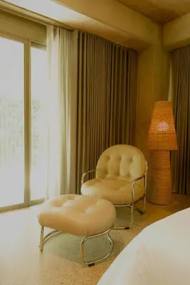 a bedroom with two chairs and a lamp and a bed at 23 Living in Medellín