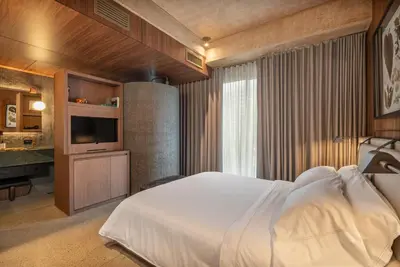 a bedroom with a white bed and a television at 23 Living in Medellín