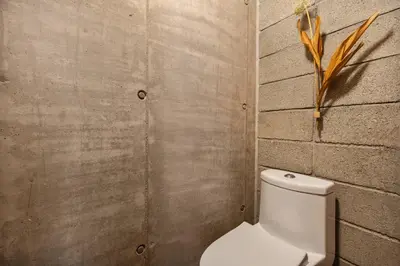 a bathroom with a white toilet in a brick wall at 23 Living in Medellín