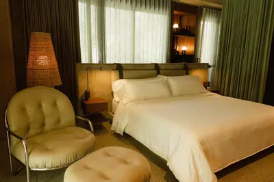 a bedroom with a large bed and a chair at 23 Living in Medellín