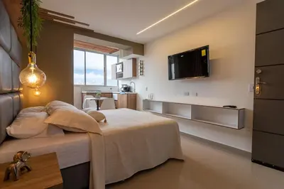 a bedroom with a bed and a tv on the wall at Apartasuite Stay & Relax Itagui in Itagüí
