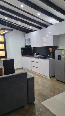a kitchen with white cabinets and a stainless steel refrigerator at Balcones Guatape Apartment in Guatapé