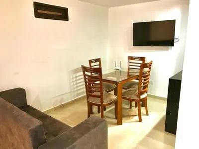 a dining room with a table and chairs and a couch at Balcones Guatape Apartment in Guatapé