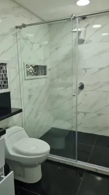 a bathroom with a toilet and a glass shower at Balcones Guatape Apartment in Guatapé