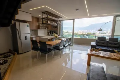 a kitchen and living room with a table and chairs at Penthouse Stay & Relax Itagui in Itagüí