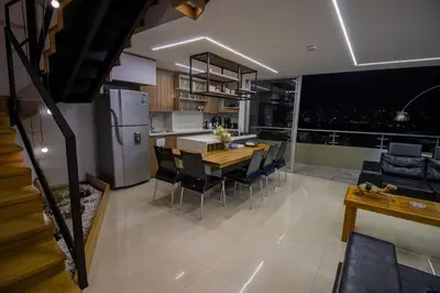 a kitchen and dining room with a table and a refrigerator at Penthouse Stay & Relax Itagui in Itagüí