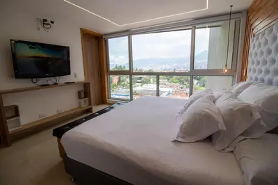a bedroom with a large bed with a large window at Penthouse Stay & Relax Itagui in Itagüí