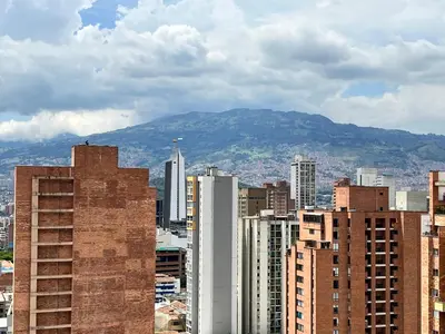 a city with buildings and a mountain in the background at Edificio Aiana Verde by Host Medellin in Medellín