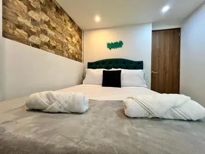 a bedroom with a large bed with two pillows at Laureles The NBHD apartments in Medellín