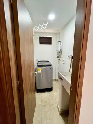 a bathroom with a refrigerator and a sink at Laureles The NBHD apartments in Medellín