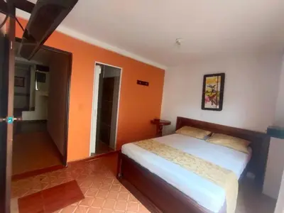 a bedroom with a bed and an orange wall at Hotel ZONA ROSA MARINILLA in Marinilla