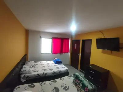 a bedroom with a bed and a flat screen tv at Hotel ZONA ROSA MARINILLA in Marinilla