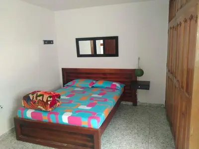 a bedroom with a bed with a wooden head board at Hotel ZONA ROSA MARINILLA in Marinilla