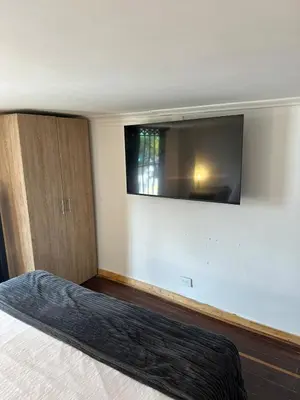 a bedroom with a bed with a flat screen tv on the wall at Modern House with Jacuzzi Stadium in Medellín