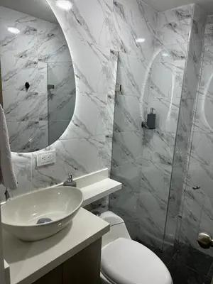 a bathroom with a sink and a toilet and a mirror at Modern House with Jacuzzi Stadium in Medellín