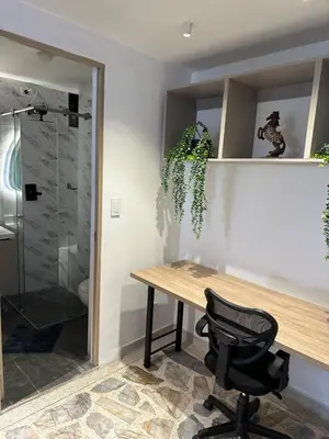 a table and a chair in a room with a shower at Modern House with Jacuzzi Stadium in Medellín