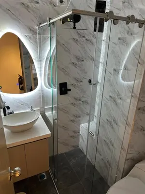 a bathroom with a sink and a glass shower at Modern House with Jacuzzi Stadium in Medellín