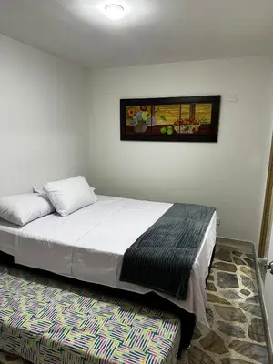 a bedroom with a bed and a picture on the wall at Modern House with Jacuzzi Stadium in Medellín