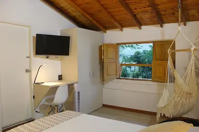 a bedroom with a bed and a desk and a window at Finca Hotel Recinto de la Gruta in Copacabana