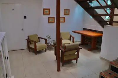 a room with chairs and a table and a piano at Finca Hotel Recinto de la Gruta in Copacabana