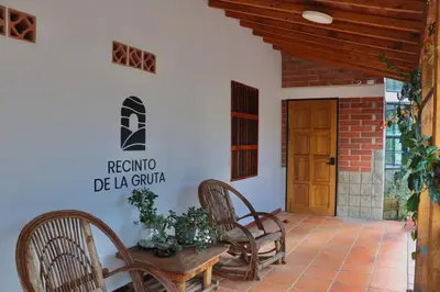 a patio with two chairs and a wooden door at Finca Hotel Recinto de la Gruta in Copacabana