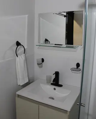 a white bathroom with a sink and a mirror at Finca Hotel Recinto de la Gruta in Copacabana