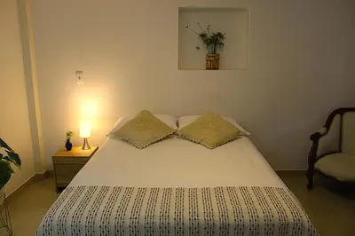 a bedroom with a white bed with two pillows at Finca Hotel Recinto de la Gruta in Copacabana