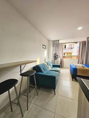 a living room with a blue couch and a bed at Ágape 301 in Itagüí