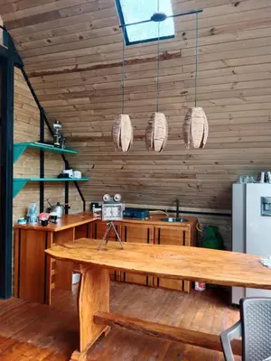 a kitchen with a wooden table and some lights at Cabaña del rio, San Luis, Antioquia in San Luis