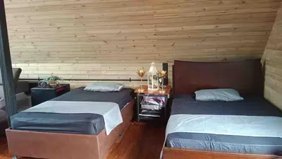 two beds in a room with wooden walls at Cabaña del rio, San Luis, Antioquia in San Luis