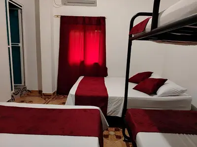 a bedroom with two beds and a red curtain at Apartamento por noches en Doradal in Las Mercedes