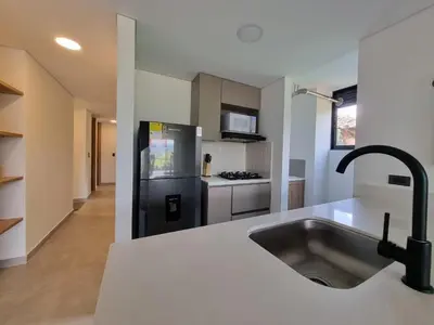 a kitchen with a sink and a black refrigerator at Apartment with a hot tub and a view of Guatapé lake in Guatapé